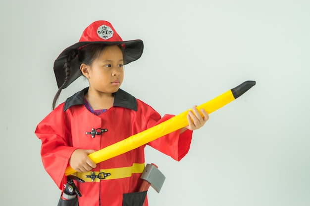 Children wearing fire extinguishers holding axe on white background