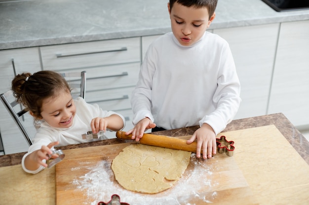 I bambini taglieranno dai biscotti di natale con le apposite forme