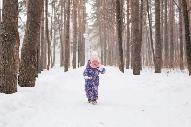 子供、冬、自然の概念-公園で雪と遊ぶ愛らしい子供のクローズアップ