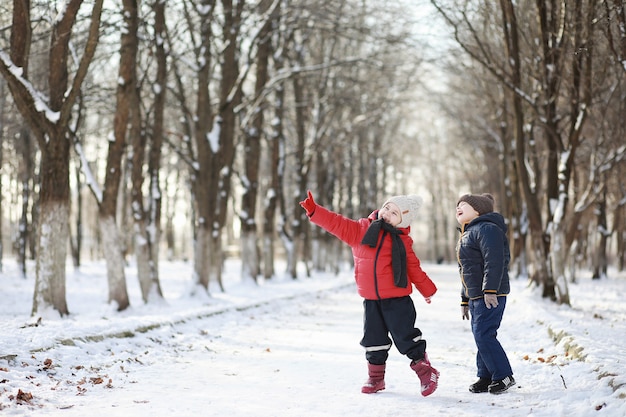 I bambini nel parco invernale giocano con la neve