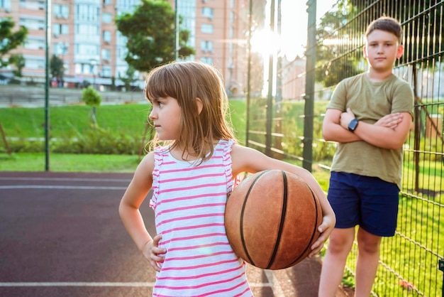 Foto bambini con una palla su un campo da basket aperto stile di vita sano e concetti sportivi