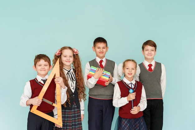 Children with books in the studio on a blue background. 