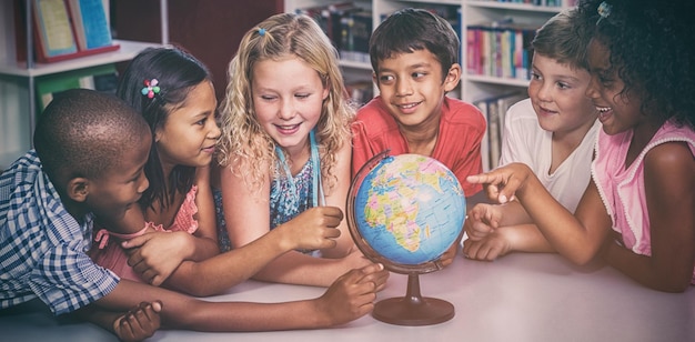 Photo children with globe on table