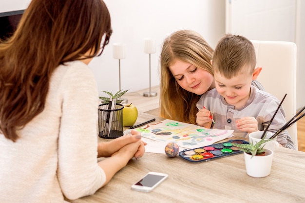 Foto bambini con mamma dipinto su carta con vernice e matite.