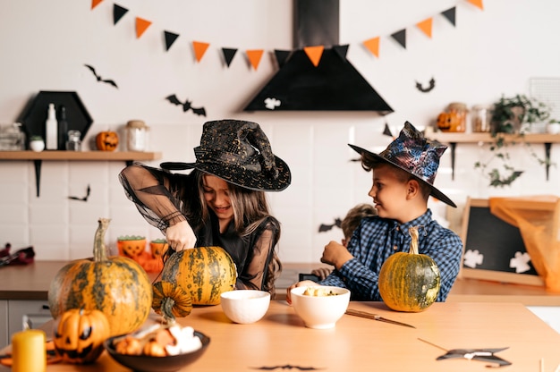 children with pumpkin carvings Happy family is getting ready for Halloween Cheerful kids at home