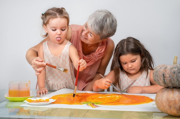 Children with senior painting pumpkin