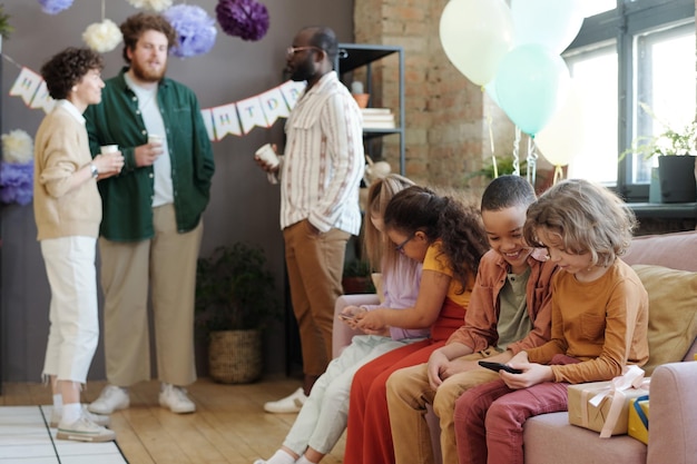 Bambini con smartphone alla festa di compleanno