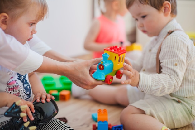 Bambini con giocattoli e infermiere in sala giochi