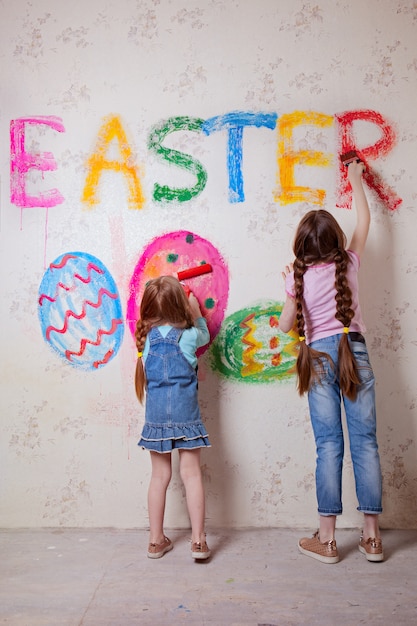 Children write on the wall the word Easter