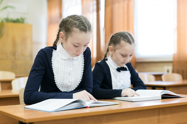 Children write while sitting at the school desk.