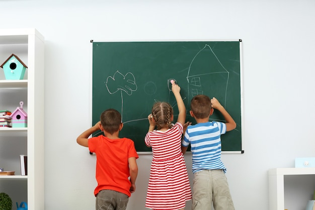 Bambini che scrivono sulla lavagna a scuola