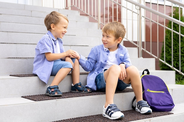 学校のポーチに座っている子供たち若い学童は学校で変化します