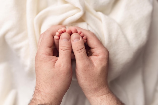 Photo children039s legs in the hands of parents on a white background