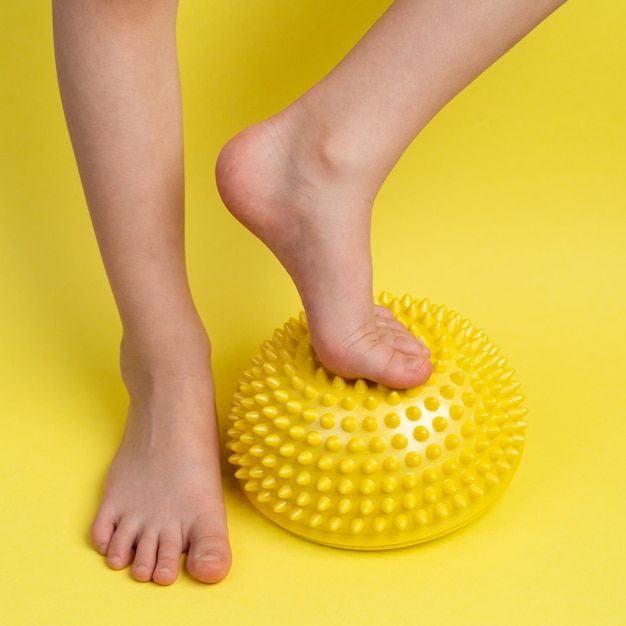 Children39s feet with a yellow balancer on a light yellow background treatment and prevention of flat feet valgus deformity of the foot