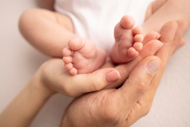 Children39s foot in the hands of mother father parents Feet of a tiny newborn close up Little baby legs Mom and her child Happy family concept Beautiful concept image of motherhood stock photo
