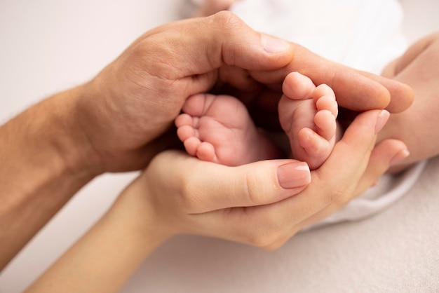 Children39s foot in the hands of mother father parents Feet of a tiny newborn close up Little baby legs