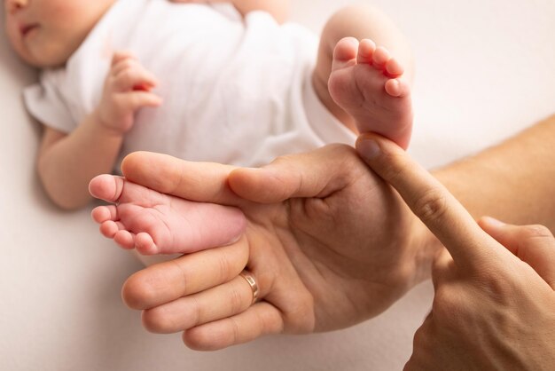 Children39s voet in de handen van moeder vader ouders Voeten van een kleine pasgeborene close-up kleine baby benen moeder en haar kind Gelukkig familieconcept Mooi concept beeld van moederschap stock foto