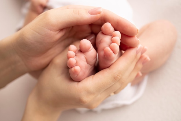 Children39s voet in de handen van moeder vader ouders Voeten van een kleine pasgeborene close-up kleine baby benen moeder en haar kind Gelukkig familieconcept Mooi concept beeld van moederschap stock foto