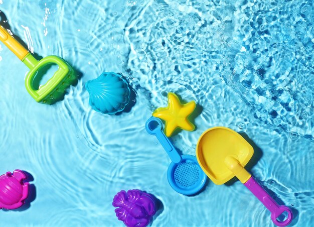 Photo childrens beach toys on splashing water