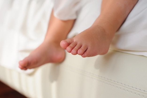 Childrens blote voeten, zittend op bed