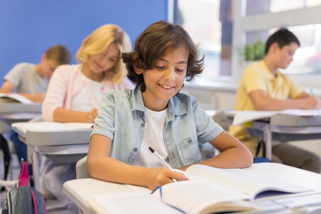 Photo childrens in classroom writing