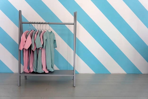 Childrens colorful clothes hang on a hanger in a store, copy space