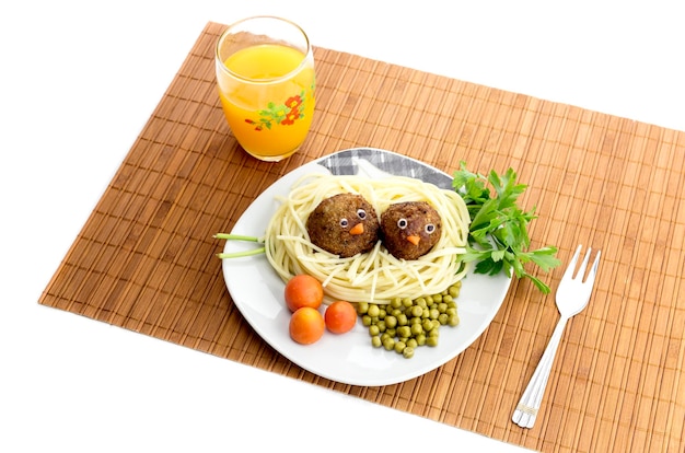 Childrens dishes Childrens meal  pasta with meatballs and fruit juice on the table closeup