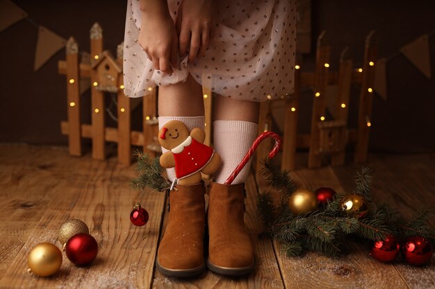 Childrens feet in brown shoes New Years lollipop and gingerbread in boots