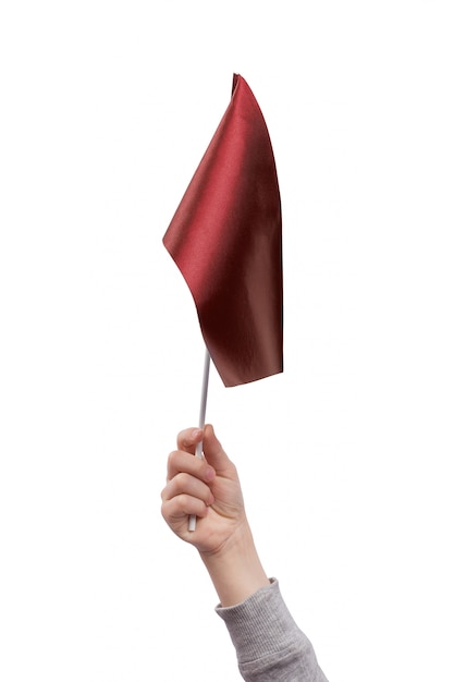 Childrens hand holding red flag isolated on white space.