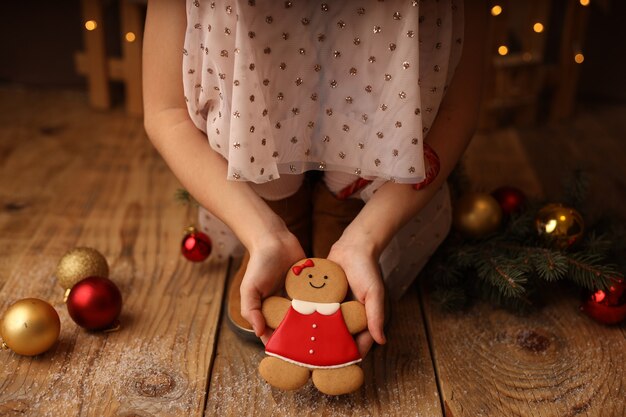 Le mani dei bambini tengono un pan di zenzero di capodanno