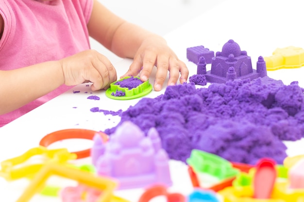 Childrens hands plays kinetic sand