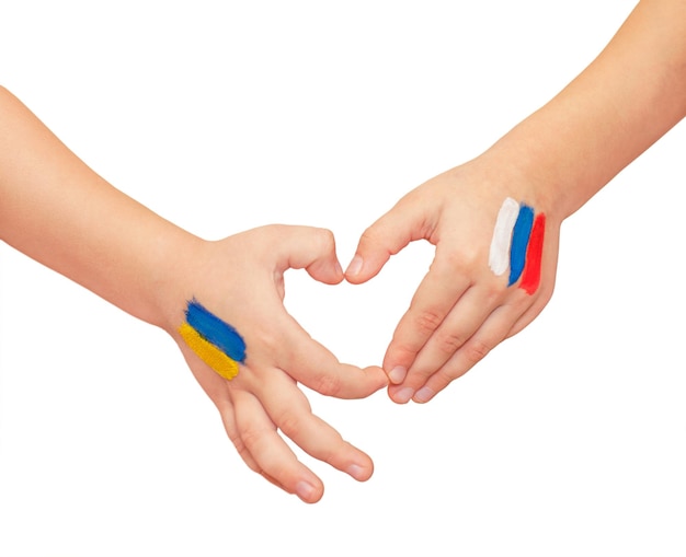 Childrens hands with painted flags are trying to connect and show the shape of a heart