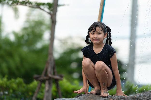 子供たちはコミュニティの畑で泥のスライドで楽しんでいます