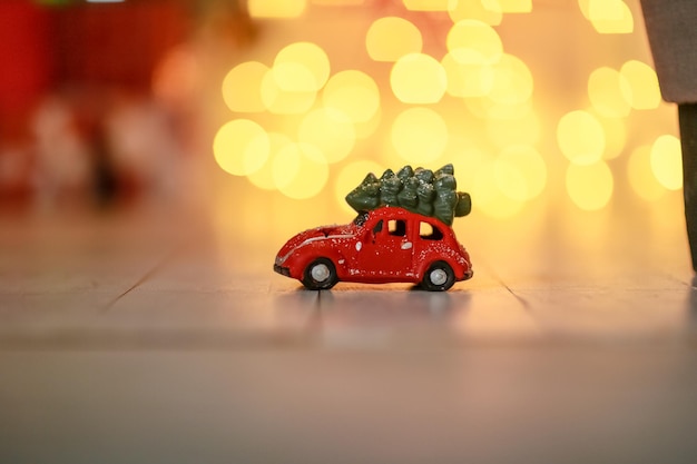 写真 クリスマスツリーを運ぶ子供の赤いおもちゃの車