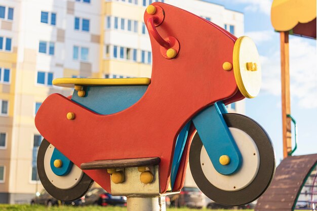 Childrens swing in the form of a motorcycle Element from the playground in the courtyard of an apartment building in a residential area of the city