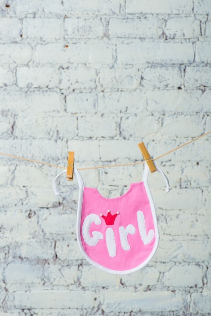 Photo childrens toddler pink saliva on a rope on a white brick wall background