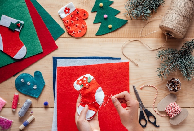 Mano del bambino che tiene la calza di feltro di natale fatta a mano