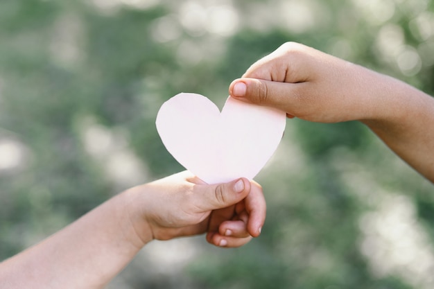 Childs hand and old hand grandmother hold heart. Concept idea of love family protecting children and elderly people grandmother friendship togetherness