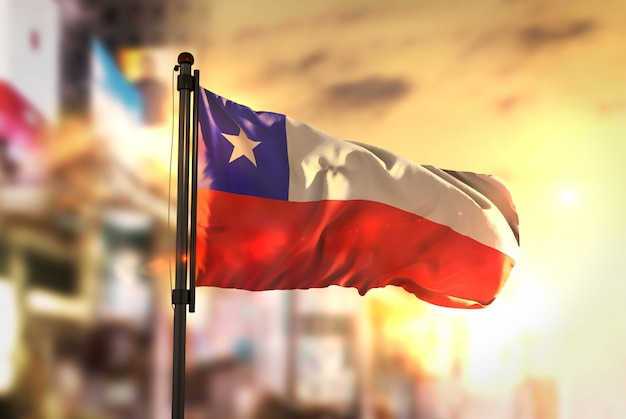 Чили Флаг против города Размытый фон на восход солнца Подсветка
