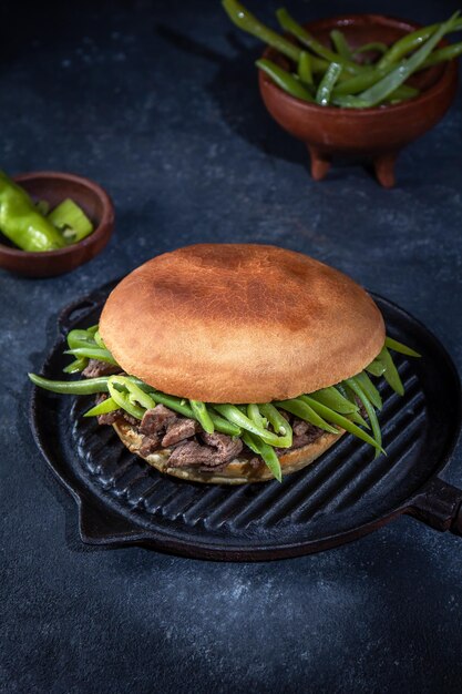 Chilean Latin american sandwich burger Chacarero with premium beef slices and green bean on black background