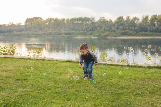 Photo chilhood, people concept. young boy playing with soap bubbles