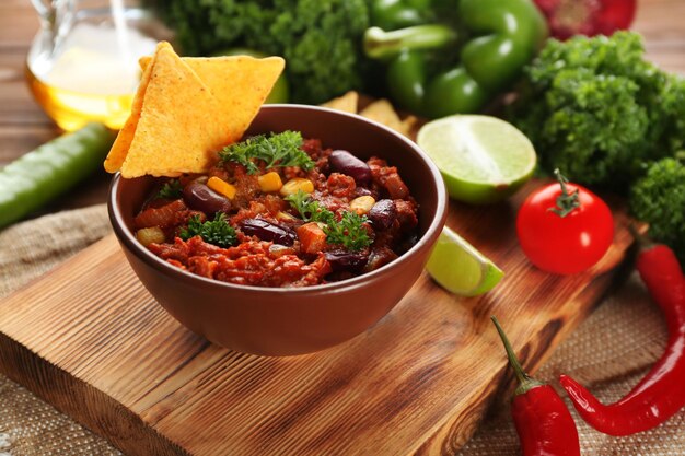 Chili con carne in kom geserveerd met friet op keukentafel