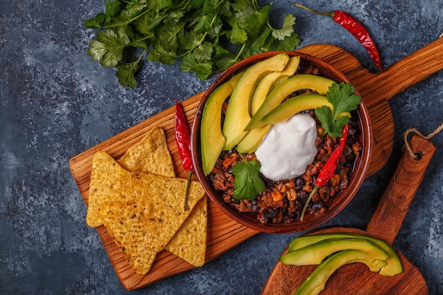 Chili con carne in kom met avocado en zure room.