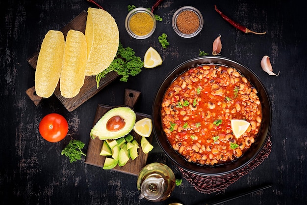 Chili con carne in kom op donkere achtergrond. mexicaanse keuken. bovenaanzicht, boven