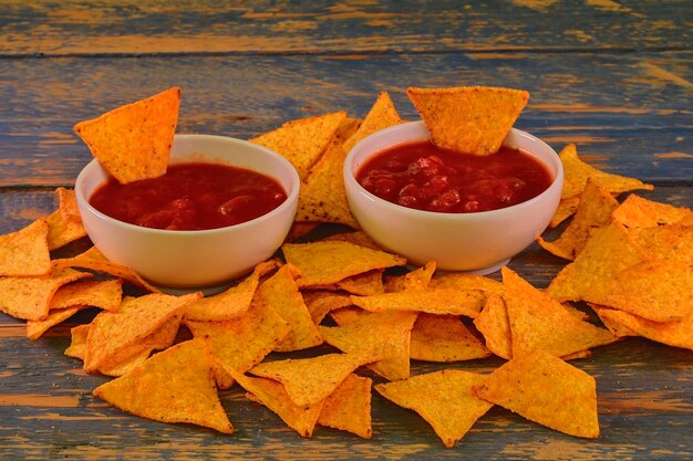 Chili corn-chips with salsa dip on wooden background