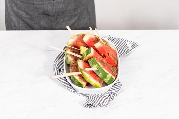 Chili lime watermelon pops on a white serving plate.