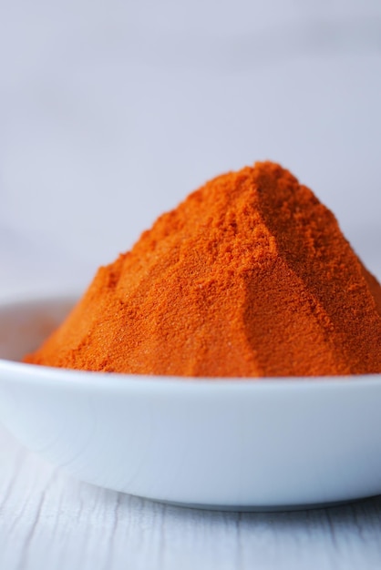 Chili powder and red peppers on table background