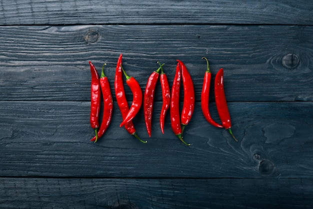 Chili red pepper. On a wooden background. Top view. Free space for your text.