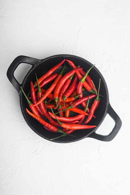 Chili Spur Pepper Set, In Gietijzeren Koekenpan, Op Witte Stenen Tafel, Bovenaanzicht Plat Lag