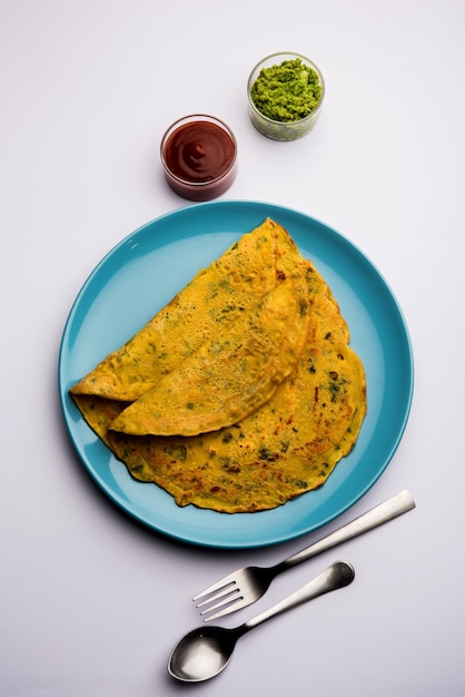 Photo chilla or besan cheela is a simple pancake made with chickpea flour and some basic ingredients served with green chutney and tomato sauce, also known as veg-omelette